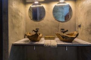 a bathroom with two sinks and two mirrors at Villa Astrolabio Refugio in Boa Vista