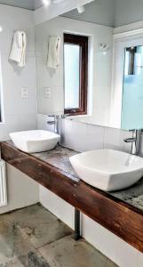 zwei Waschbecken auf einer Theke im Bad in der Unterkunft Hotel y Cabañas Molino Viejo in Puerto Varas