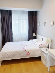 a bedroom with a white bed and a window at Koza Apartment, next to Akbati Shopping Mall and Tennis court Soul Entertainment in Istanbul
