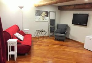 a living room with a red couch and a tv at Chiossone Suites in Genova