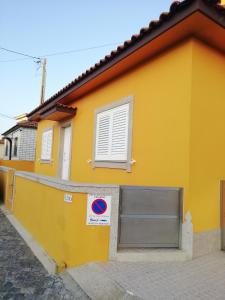 un edificio amarillo con una puerta y una señal en él en Casa da Fátima, en Vila Chã