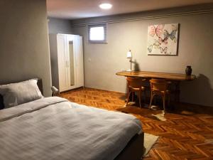 a bedroom with a bed and a table with chairs at Greencajt in Jakopovec