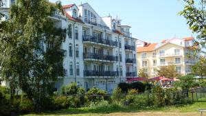 ein großes weißes Gebäude mit Balkonen darauf in der Unterkunft Apartmenthaus Atlantik in Kühlungsborn