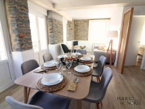 une salle à manger avec une table et des chaises en bois dans l'établissement Apartamentos Puerto Norte - Apto 2, à Puerto de Vega