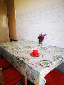 einen Tisch mit einem Tischtuch und einer roten Tasse darauf. in der Unterkunft S'arrulloni in Cagliari