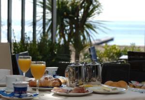 una mesa con desayuno y vasos de zumo de naranja en Hotel Atlantico, en Lido di Jesolo