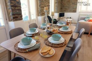 a wooden table with plates of food on it at Apartamentos Puerto Norte - Apto 3 in Puerto de Vega
