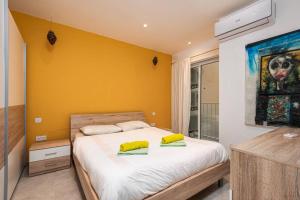 1 dormitorio con 1 cama con 2 almohadas amarillas en Sliema Smart SeaView Apartment, en Sliema