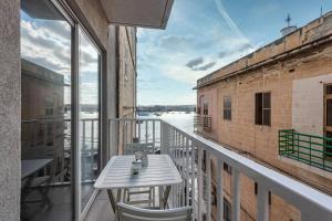 balcón con mesa y vistas al agua en Sliema Smart SeaView Apartment, en Sliema
