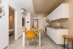 cocina con mesa de comedor y sillas amarillas en Sliema Smart SeaView Apartment, en Sliema