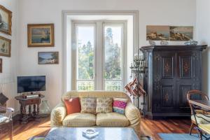 un soggiorno con divano e una grande finestra di Villa Niobe - Exclusive Lakefront Apartment With Private Beach a Stresa