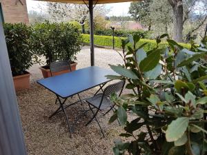 una mesa azul y sillas sentadas bajo una sombrilla en Agriturismo Il Poggiarello, en Siena