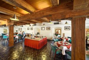 een restaurant met tafels en stoelen en mensen op de achtergrond bij Hotel Mlýn in Český Krumlov