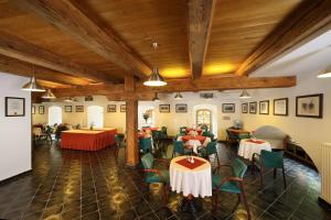 a restaurant with tables and chairs and wooden ceilings at Hotel Mlýn in Český Krumlov
