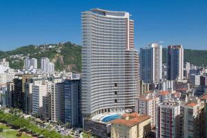 een groot hoog gebouw in een grote stad bij Unlimited - Frente ao Mar. Apt todo mobiliado. in Santos