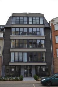 a tall black building with a car parked in front of it at Margaux in De Panne