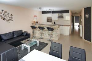 uma sala de estar com um sofá e cadeiras e uma cozinha em Margaux em De Panne