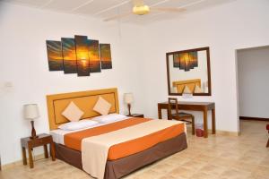a bedroom with a bed and a desk and a bed sidx sidx sidx at Yolanda Villa Negombo in Negombo
