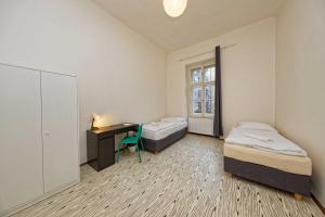 Zimmer mit 2 Betten, einem Schreibtisch und einem Fenster in der Unterkunft Apartment Manesova 4 in Prag