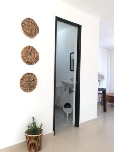 a hallway with a mirror and two baskets on a wall at Villas del Guali - Piscina Privada in Santa Fe de Antioquia