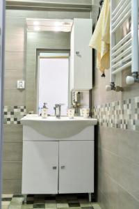 a bathroom with a white sink and a window at Apartment on Rustaveli Avenue in Kutaisi +64 photos