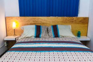 a bed with a blue headboard and two pillows at Gdl Collection for families in Guadalajara