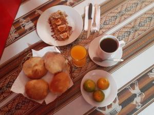 a table with plates of food and a cup of coffee at Krusty Hostel B&B in Huaraz