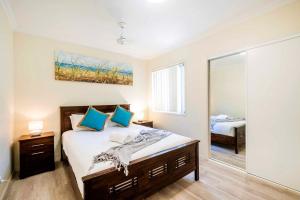a bedroom with a bed and a large mirror at Oceania 11 - LJHooker Yamba in Yamba