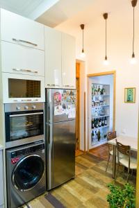 a kitchen with a stainless steel refrigerator and a table at Apartment on Rustaveli Avenue in Kutaisi