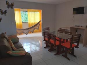 a living room with a table and chairs and a couch at Maragogi Apartamentos e Suites in Maragogi