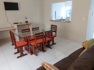 a dining room with a glass table and chairs at Maragogi Apartamentos e Suites in Maragogi