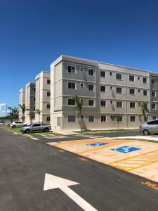 um parque de estacionamento vazio em frente a um grande edifício em Apartamento da Chris em Palmas