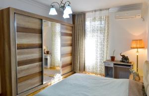 een slaapkamer met een grote schuifdeur en een raam bij Apartment on Rustaveli Avenue in Koetaisi