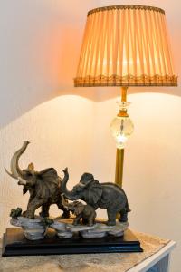 een standbeeld van drie olifanten op een tafel naast een lamp bij Apartment on Rustaveli Avenue in Koetaisi