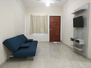 a living room with a blue couch and a door at Casa Unamar Cabo Frio/RJ. in Cabo Frio