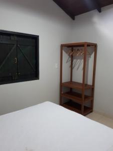 a bedroom with a bed and a dresser with a mirror at Loft Pireneus 1 in Pirenópolis