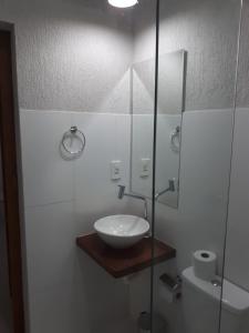 a bathroom with a sink and a glass shower at Loft Pireneus 2 in Pirenópolis