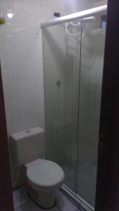 a bathroom with a toilet and a glass shower at ILHA DOS CORAIS -Ap 304 C in Balneário Praia do Leste