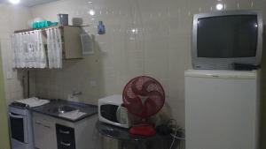 a small kitchen with a microwave and a tv at ILHA DOS CORAIS -Ap 304 C in Balneário Praia do Leste