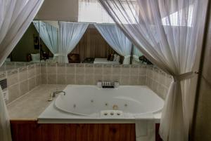 a white bath tub sitting under a window in a bathroom at Best Western Endeavour Motel in Maitland