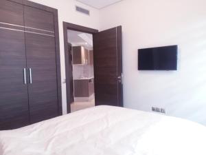 a bedroom with a bed and a flat screen tv at MAARIF LUXURY APART -Urban Massira IV- in Casablanca