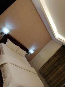 a bedroom with a bed with white sheets and pillows at Randan in Riyadh