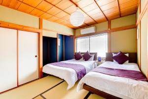 two beds in a room with blue and yellow walls at Chikyuutabikazoku USJ Ⅱ in Osaka