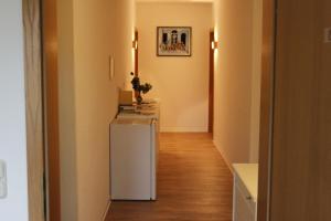 a hallway with a white refrigerator in a room at Pension Am Bodden in Ribnitz-Damgarten