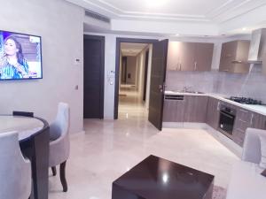 a large kitchen with a table and a counter at MAARIF LUXURY APART -Urban Massira IV- in Casablanca