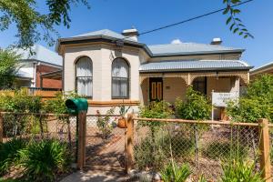 a house with a fence in front of it at 94Best Apartments in Wagga Wagga