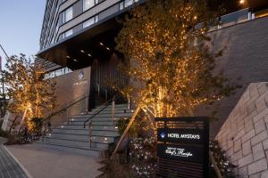 ein Gebäude mit einer Treppe mit Weihnachtsbeleuchtung in der Unterkunft HOTEL MYSTAYS Fuji Onsen Resort in Fujiyoshida