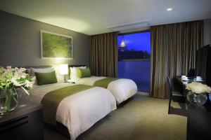 una camera d'albergo con due letti e una finestra di Aventree Hotel Busan a Busan