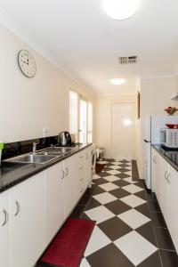 una cocina con suelo a cuadros en blanco y negro en 94Best Apartments en Wagga Wagga