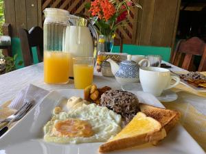 un plato de desayuno con huevos y tostadas en Garden of Heliconias Lodge en Drake